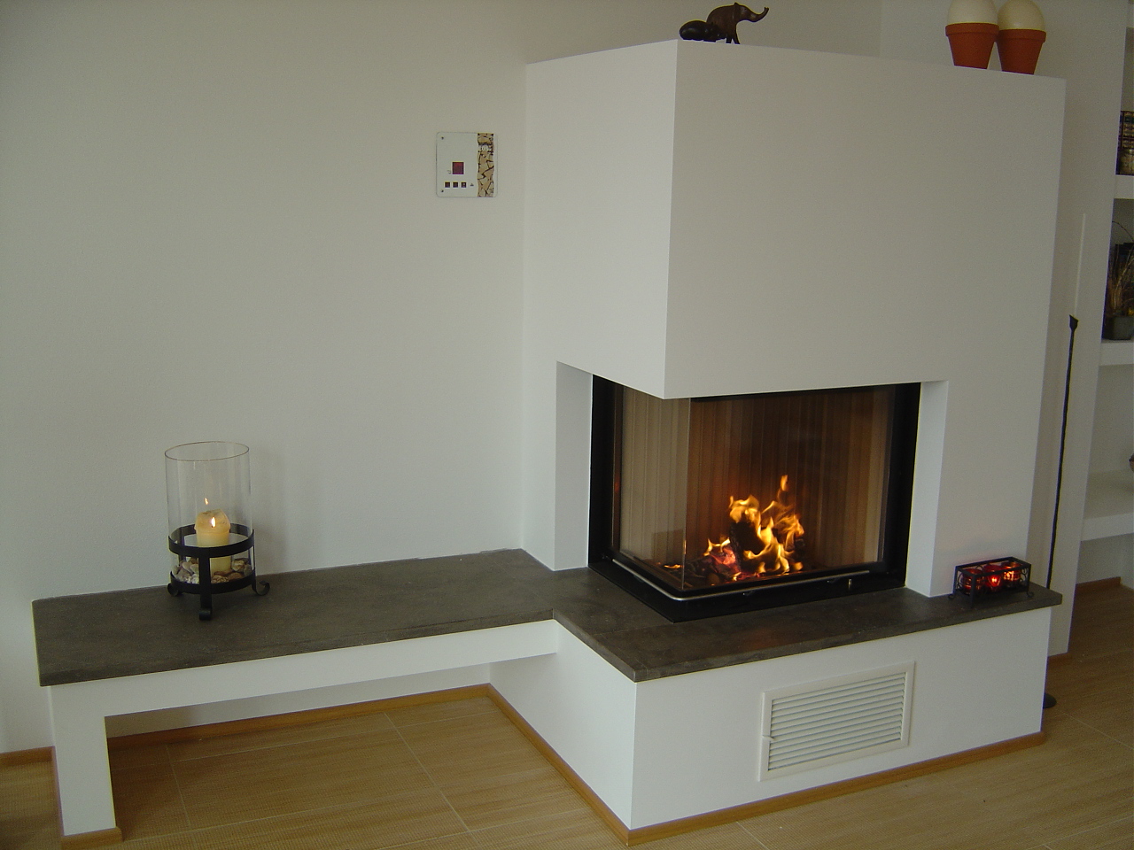 Moderner Kamin über Eck mit Sitzbank